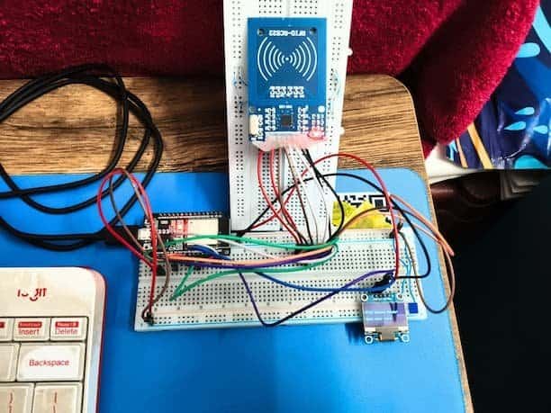 ESP32 RFID RC522 attendance system on vertical breadboard with OLED display showing RFID system ready.