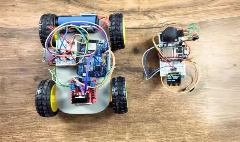 Top-down view of a custom 4WD smart car built with Arduino R4 WiFi and L298N motor driver, sitting next to an ESP32 joystick remote featuring dual SSD1306 OLED dashboards for zero-lag UDP telemetry.